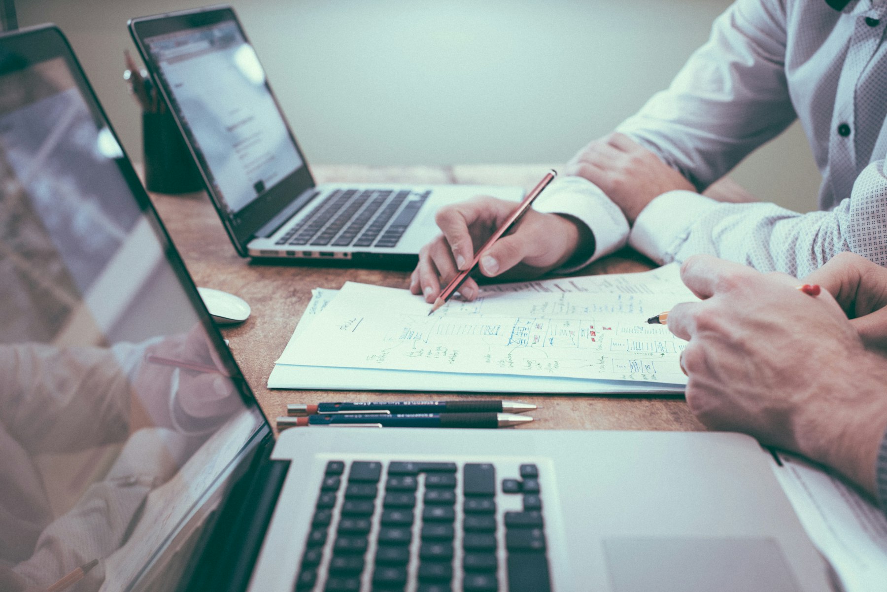 Person reviewing documents and laptop